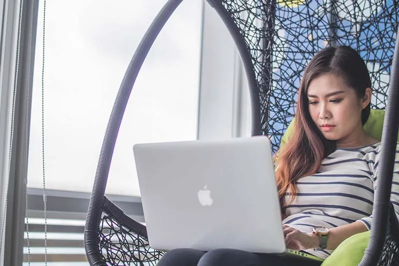 young professional woman works on a mac laptop