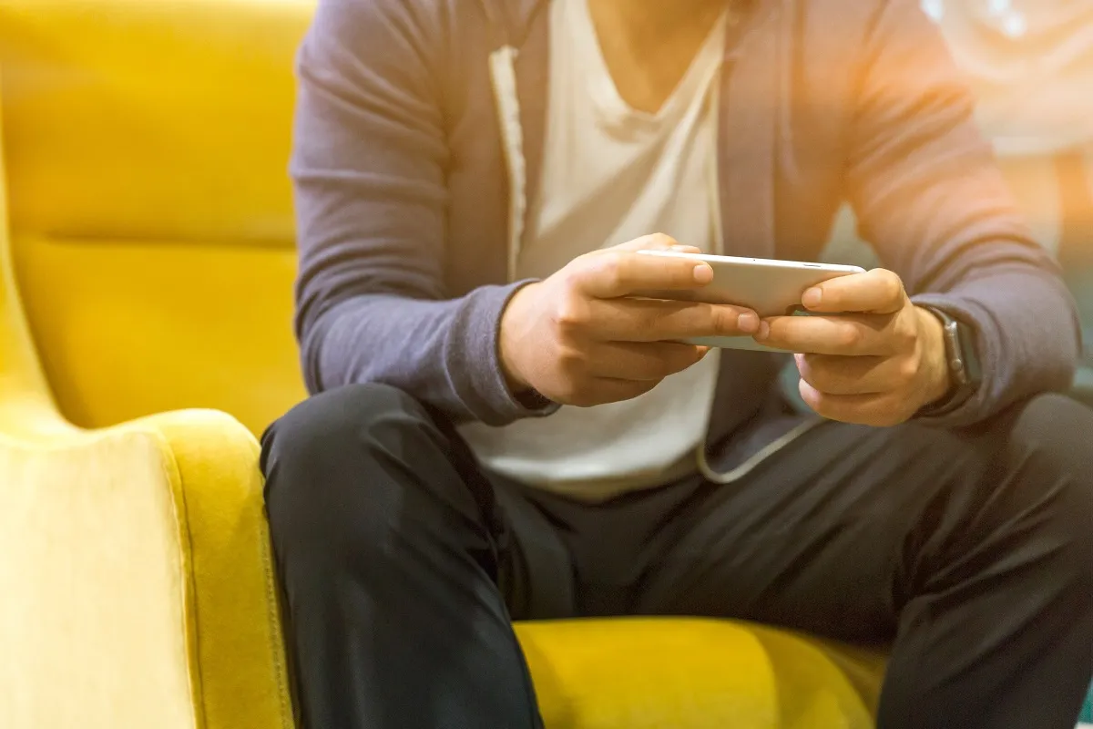 A man using his cell phone on a couch