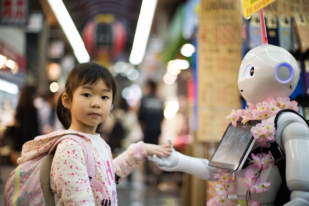 a child shaking hands with a robot