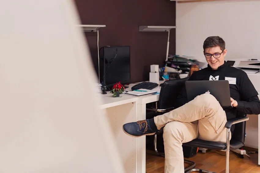 a man sitting in the chair with the laptop