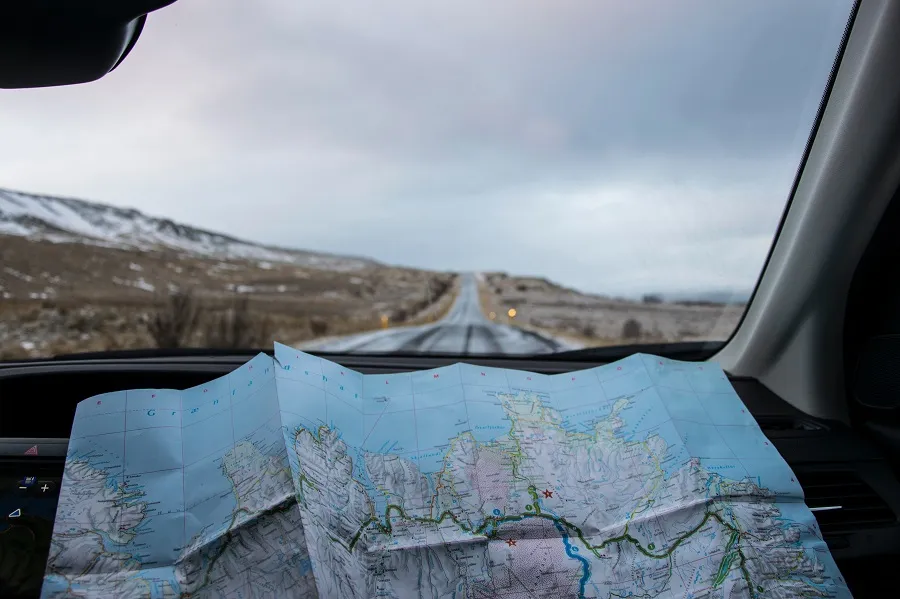 a person with a map driving on the highway